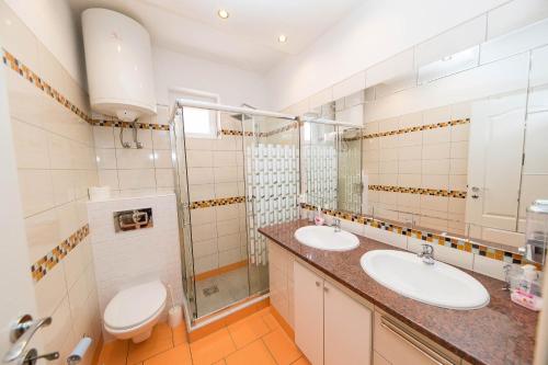 een badkamer met 2 wastafels en een toilet bij Apartments Martic Janja in Dramalj