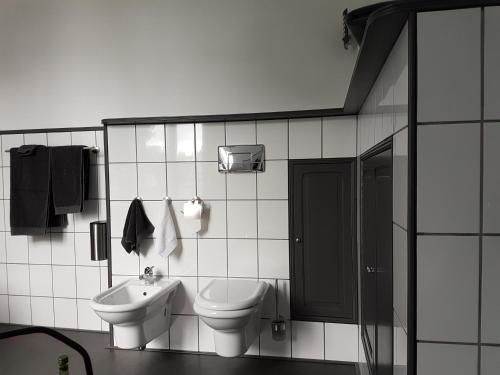 a white bathroom with a toilet and a sink at ANNO 1919 in Swalmen