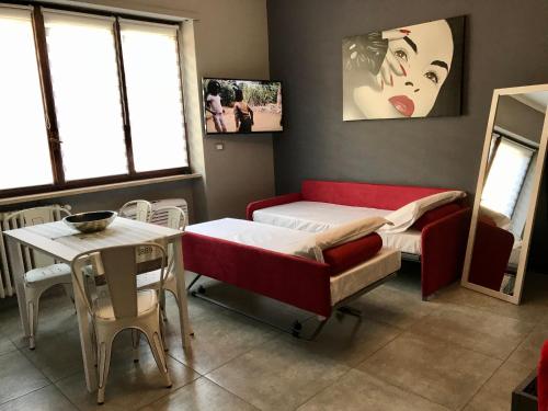 a room with a bed and a table and window at HappyHome Appartamento 4 posti letto Rivarolo Canavese in Rivarolo Canavese
