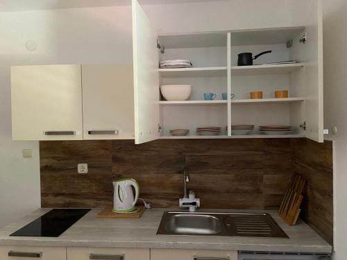a kitchen with white cabinets and a sink at Apartments Simoneta in Malinska