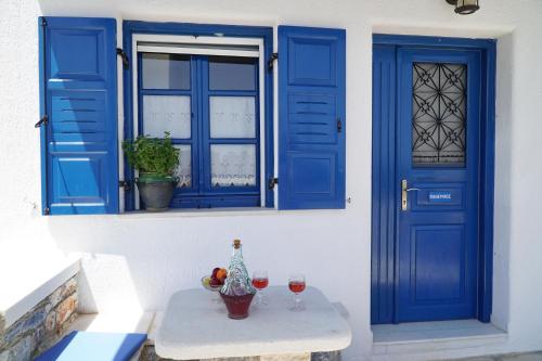 a blue door and a table with glasses of wine at Moutsouna Beach II in Moutsoúna