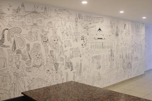 a wall covered in drawings on a wall at Aura Residency in Trichūr
