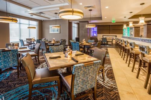 a restaurant with tables and chairs and a bar at Holiday Inn South Jordan - SLC South by IHG in South Jordan