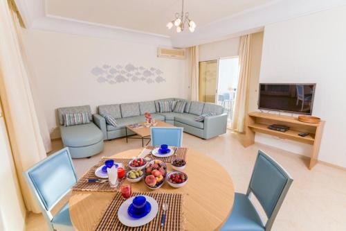 a living room with a table and a couch at Les Deux Rives in Hammamet Sud