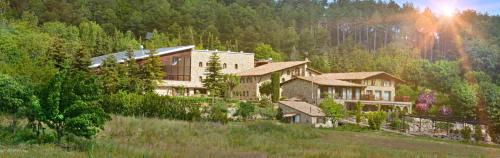 a large building in the middle of a mountain at El Jou Nature in Sant Corneli de Cercs 