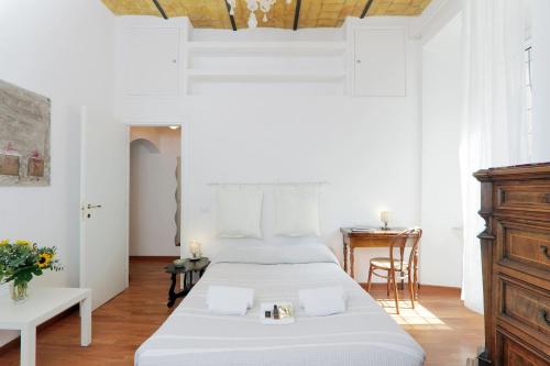 a white bedroom with a bed and a desk at RomeAsYouLike - Colosseo Experience 23 in Rome