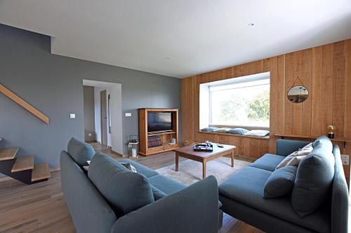 a living room with a blue couch and a table at Ty Dag - La Désirade proche plage et jacuzzi in Roscoff