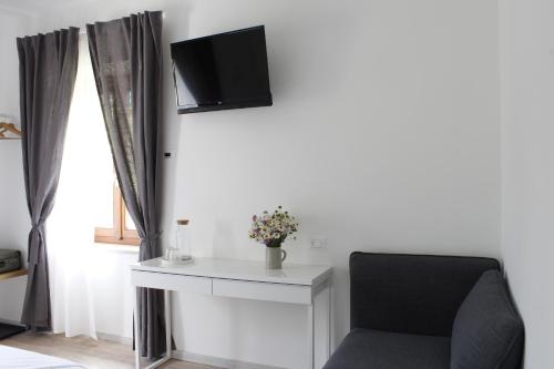 a living room with a chair and a tv on the wall at B&B Casa Gori in Madice