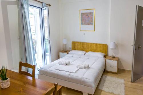 een slaapkamer met een wit bed met twee knuffels erop bij Cloud 5 Apartment in Kalamata