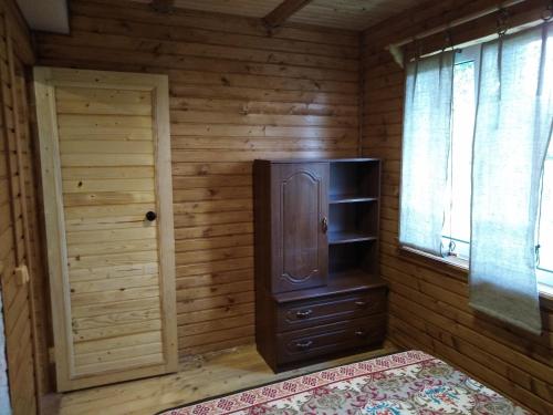 a room with a wooden room with a stove and a door at ЗАТИШОК in Oriv