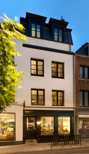 a white building with black windows at La Maison Haute guesthouse in Brussels