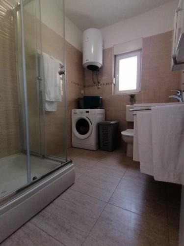 a bathroom with a shower and a washing machine at Villa Mir Pridraga in Pridraga