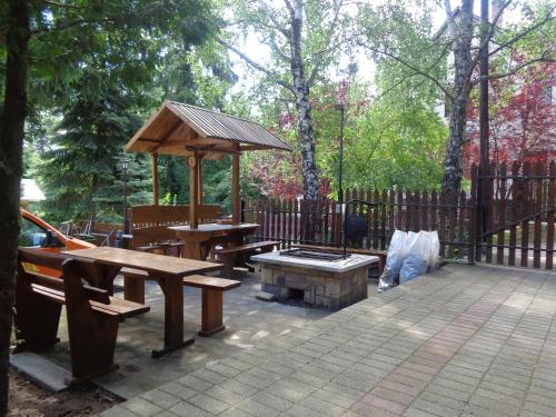 een patio met banken, een picknicktafel en een paviljoen bij Kilátó úti Vendégház in Matrafured