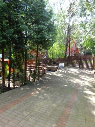 einen Park mit Bänken, einem Zaun und Bäumen in der Unterkunft Kilátó úti Vendégház in Matrafured