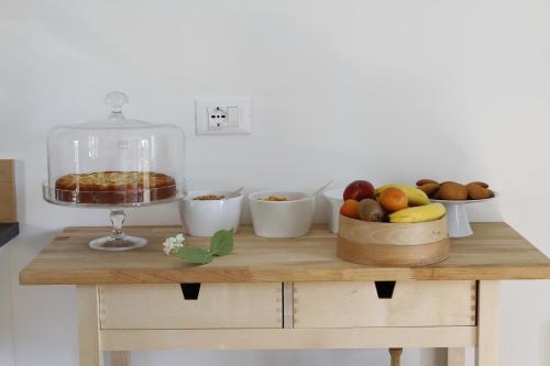 a table with a bowl of fruit and a cake at B&B Casa Gori in Madice