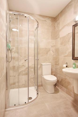 a bathroom with a shower and a toilet and a sink at The Farmers Kitchen Hotel in Wexford