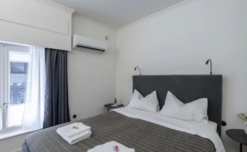a bedroom with a large bed with two towels on it at House in House at the Heart of Exarchia, extremely central in Athens