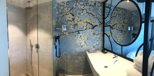 a bathroom with a shower with a sink and a mirror at Hotel Van der Valk Maastricht in Maastricht