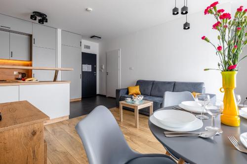 a kitchen and a living room with a table and chairs at Symphony Baltica Towers Apartamenty in Gdańsk