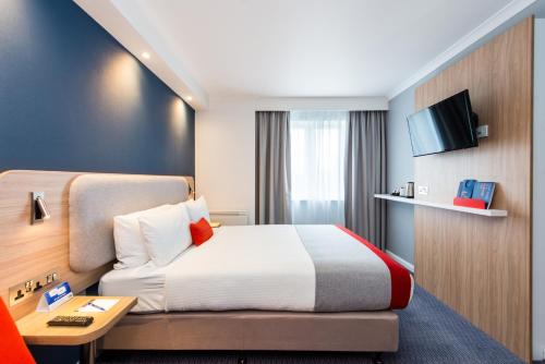 a hotel room with a bed and a tv at Holiday Inn Express Strathclyde Park M74, Jct 5 by IHG in Motherwell