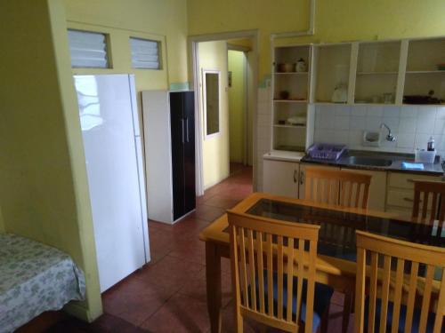 cocina con mesa, sillas y nevera en Apartamento em bairro Floresta, en Porto Alegre