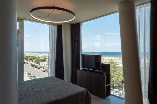 a bedroom with a bed and a large window at Hotel Commodore in Cervia