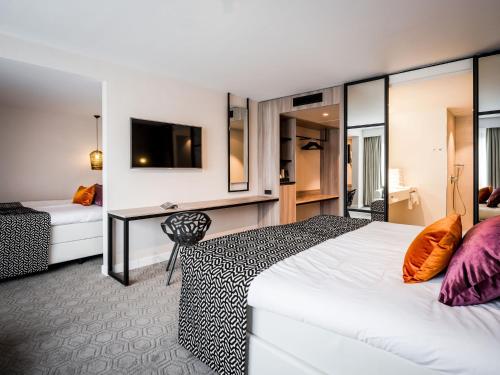 a hotel room with a bed and a desk at Hotel Van der Valk Maastricht in Maastricht