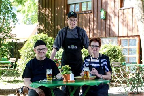 un gruppo di tre persone seduti a un tavolo di Hotel Gasthof Metzgerei Drei Linden a Fulda