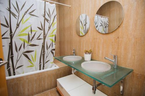 uma casa de banho com dois lavatórios e dois espelhos em LA SURFERA APARTMENT em Tarragona
