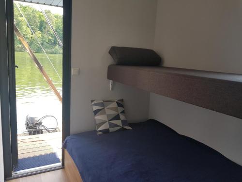 sypialnia z łóżkiem piętrowym obok okna w obiekcie Domki pływające Houseboat4U, Mazury w mieście Ruciane-Nida