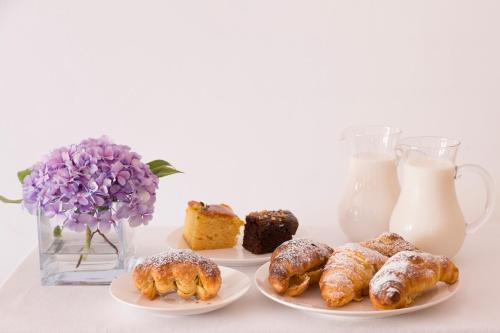 a table with three plates of pastries and a jug of milk at HOTEL ZI'NTONIO in Scala