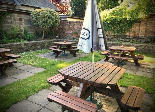 an umbrella sitting on a picnic table with benches at The White Horse Inn, Clun in Clun