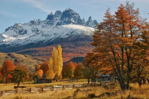 a fence in a field with a mountain in the background at Casa Cerro Castillo in Villa Cerro Castillo