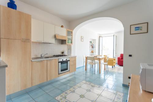 a kitchen with wooden cabinets and a table in it at LUIMAR Holiday House in Amalfi