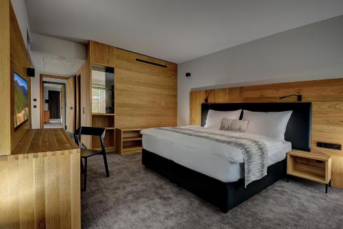 a bedroom with a bed and a desk and a bed sidx sidx sidx at Grand Hotel Hradec in Pec pod Sněžkou