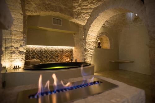 a bath room with a tub and a fireplace at La Mandorla Luxury Trullo in Alberobello