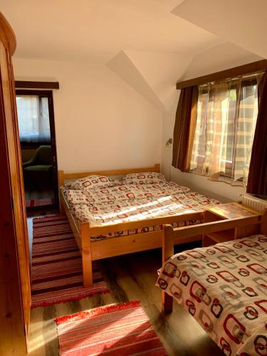 a bedroom with two beds and a window at Casa Maria Izvorul Muresului in Izvoru Mureşului
