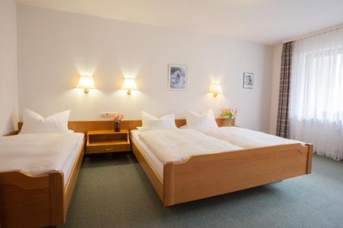 um quarto de hotel com duas camas e uma janela em Rustikale 2 Zi.-FeWo 70 qm Barrierefrei Nähe Freiburg em Simonswald