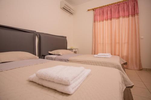 a room with two beds with white towels on them at Pistakion Houses in Aegina Town