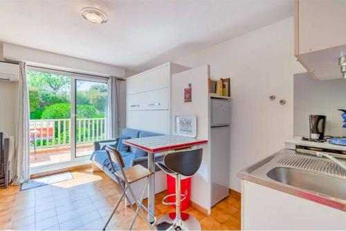 une cuisine avec un comptoir, une table et des chaises dans l'établissement Studio entre verdure et mer, à Sausset-les-Pins