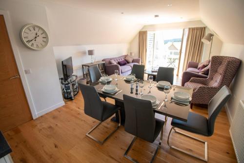 a dining room with a table and chairs and a clock at Inchmarlo Golf Resort, Banchory Villa 38 AS00482F in Inchmarlo