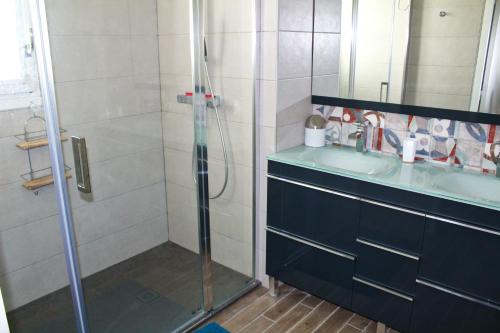 ein Bad mit einer Dusche und einem Waschbecken in der Unterkunft LE PLAZA HYPERCENTRE TERRASSE eT PARKING in Saint-Jean-de-Luz