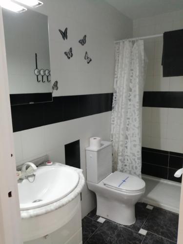 a bathroom with a white toilet and a sink at Casas Holiday - Puerto Romano in La Mata