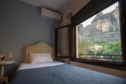 a bedroom with a bed and a large window at The house under the rocks of Meteora 1 in Kalabaka