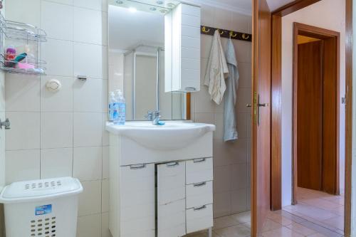 a white bathroom with a sink and a mirror at Villa Sofia in Mesimvría