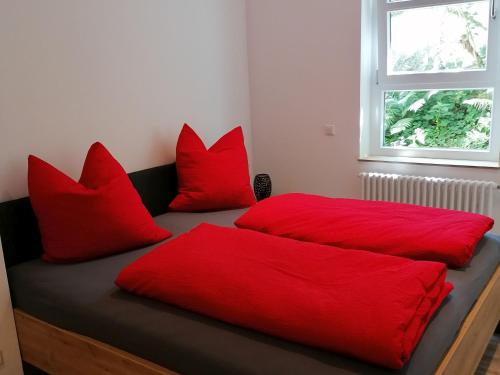 ein Schlafzimmer mit zwei roten Kissen auf einem Bett in der Unterkunft Jogis Ferienwohnungen in Freiburg im Breisgau