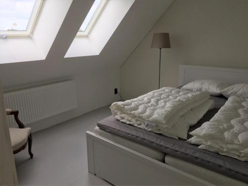 a bedroom with two beds and a skylight at Annagården Österlen in Kivik
