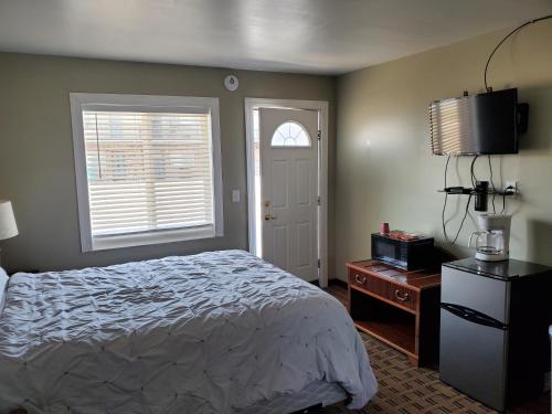 a bedroom with a bed and a television and a window at Golden Gate Lodging in Plattsburgh