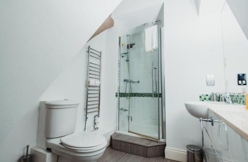 a bathroom with a toilet and a glass shower at The Old Palace Lodge in Lincoln