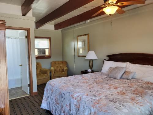 1 dormitorio con 1 cama y ventilador de techo en Golden Gate Lodging, en Plattsburgh